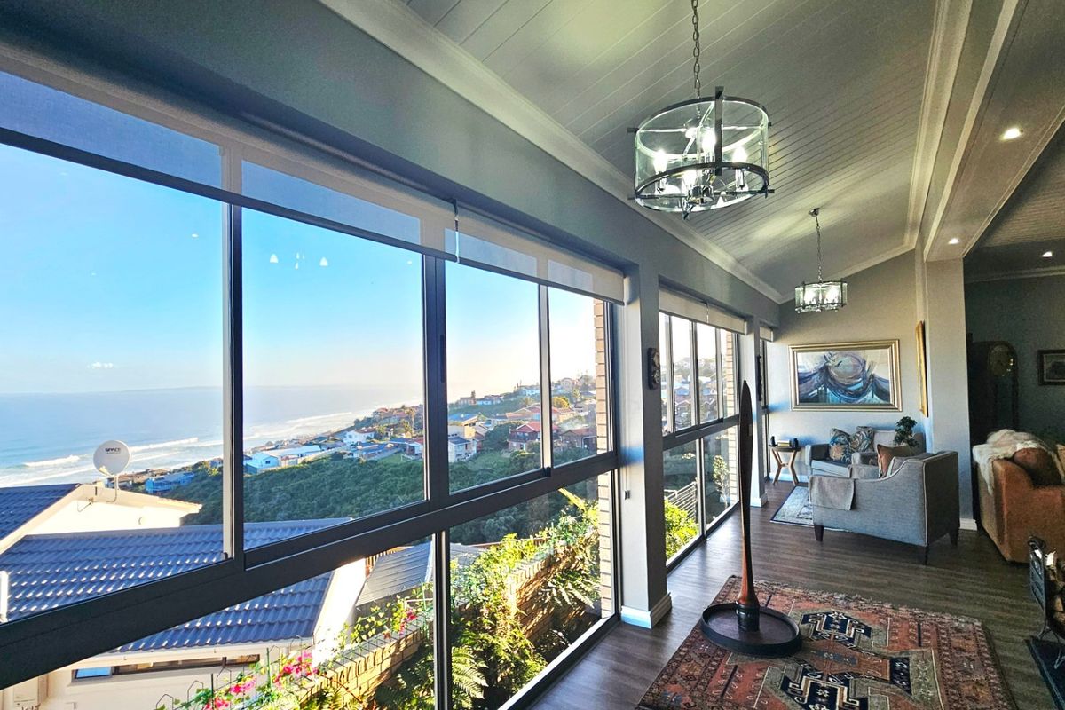 Spacious living area featuring expansive floor-to-ceiling windows with panoramic coastal views, high-quality finishes, and a bright, airy atmosphere.