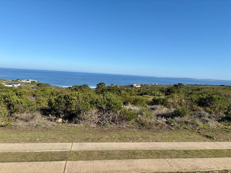 A scenic view overlooking the coastal landscape and ocean from the residential land plot.