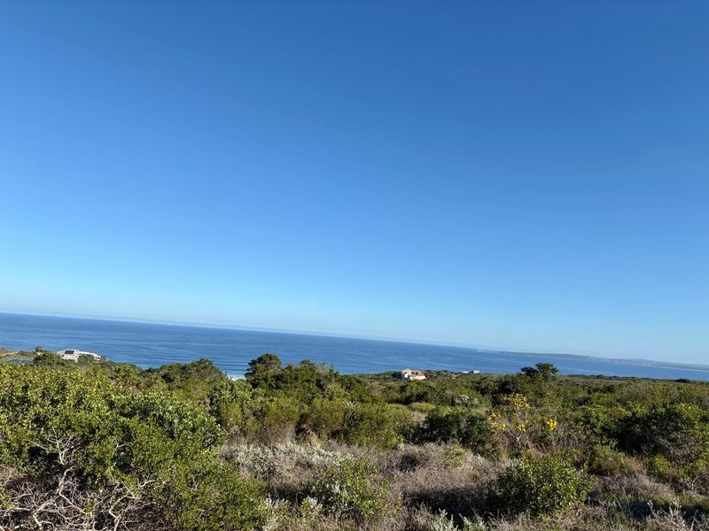 A scenic view of the coastline and ocean from the vacant residential land, featuring natural coastal vegetation and clear horizon.