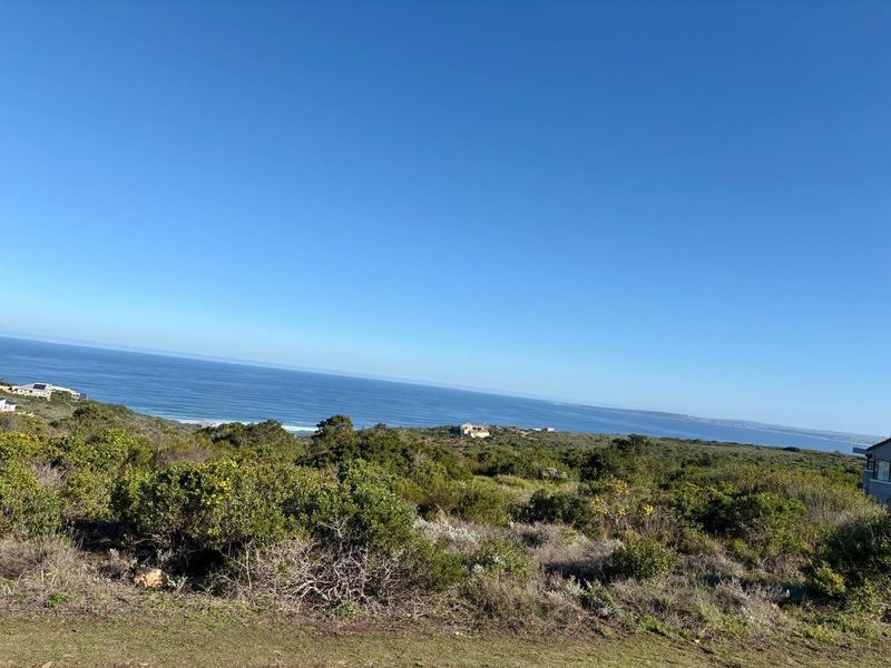 A scenic view of the coastal landscape and ocean, showcasing the natural beauty and elevated position of the vacant residential land.