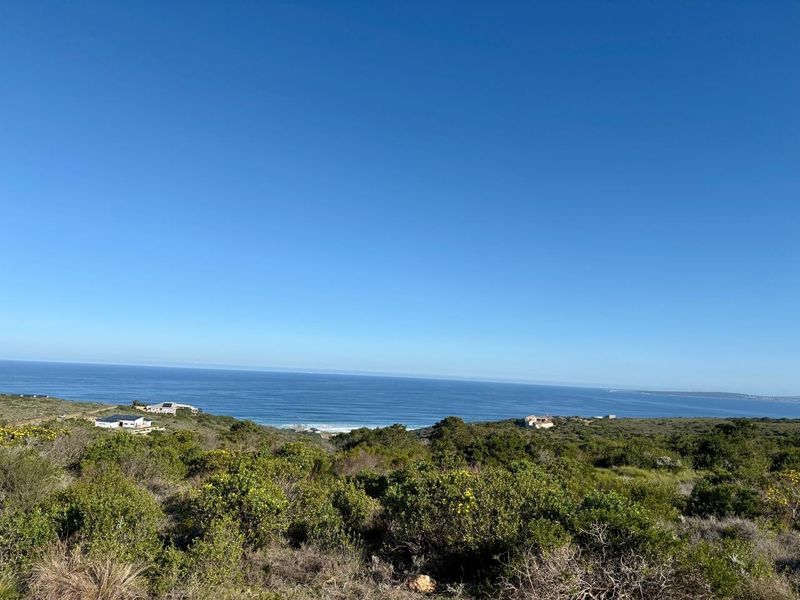 A scenic elevated view overlooking the coastal landscape and ocean, showcasing the natural surroundings of the vacant residential land.