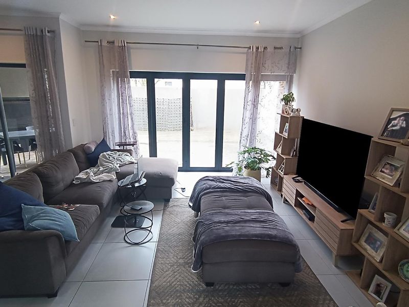 A comfortable living room featuring large sliding glass doors that provide natural light and direct access to the outdoor patio area.