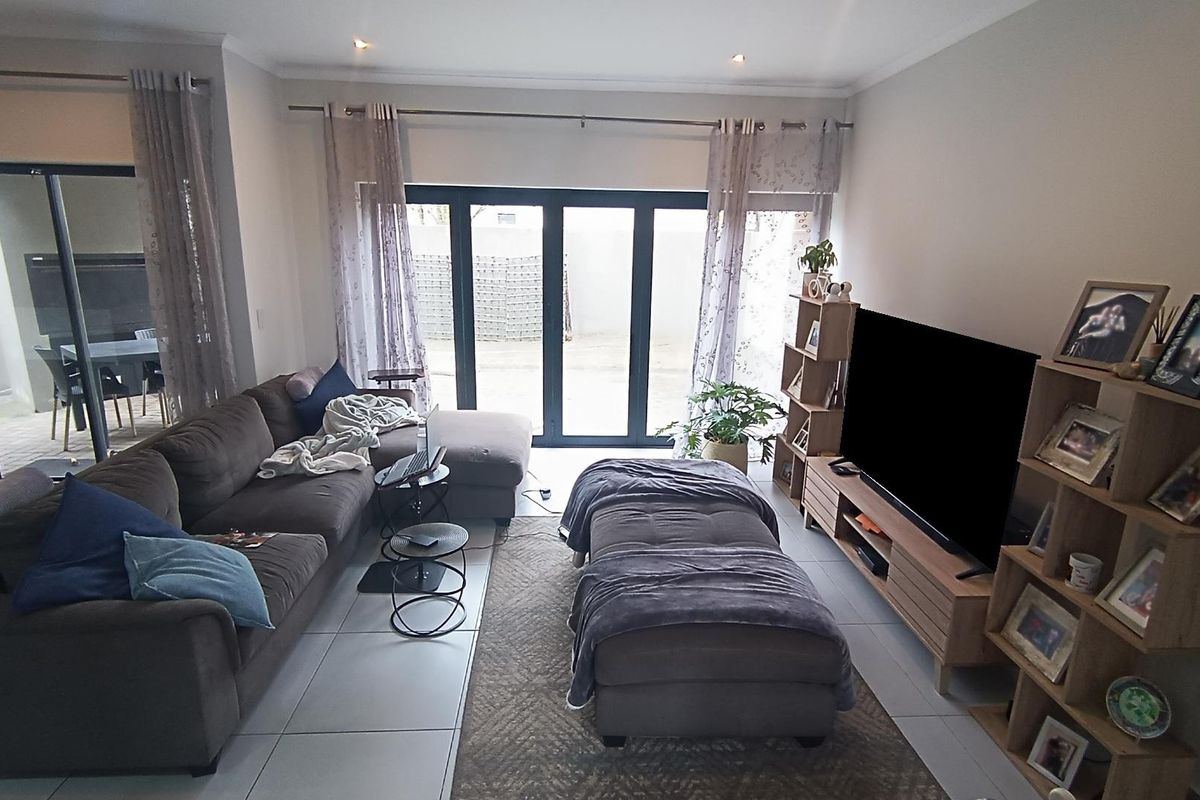 A comfortable living room featuring large sliding glass doors that provide natural light and direct access to the outdoor patio area.