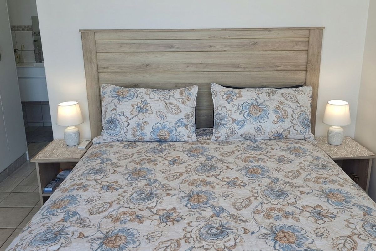 A well-maintained bedroom featuring tiled flooring and a built-in wardrobe, with a view into an adjacent bathroom area.