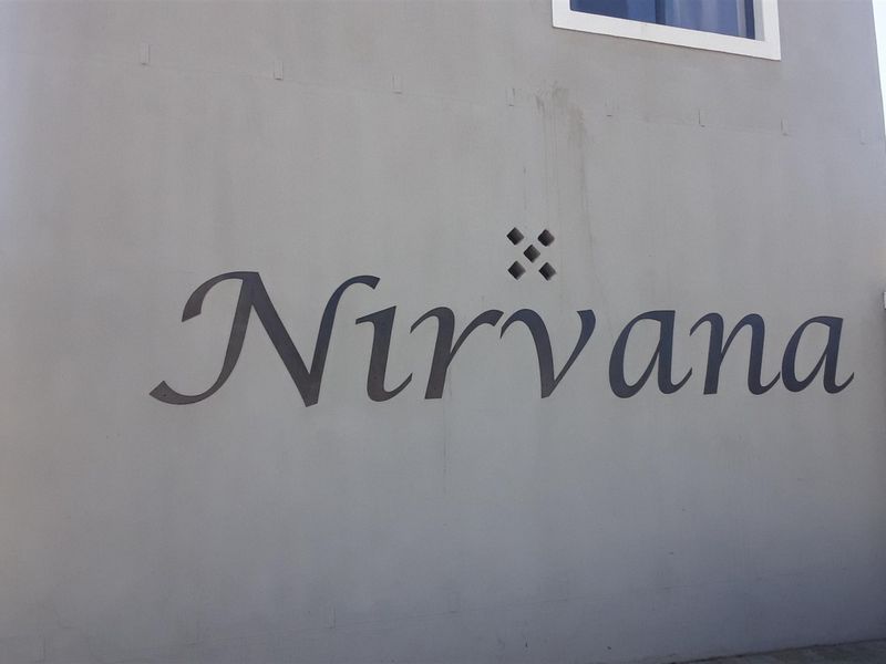 Exterior view of the building facade featuring the Nirvana complex signage on a painted wall surface.