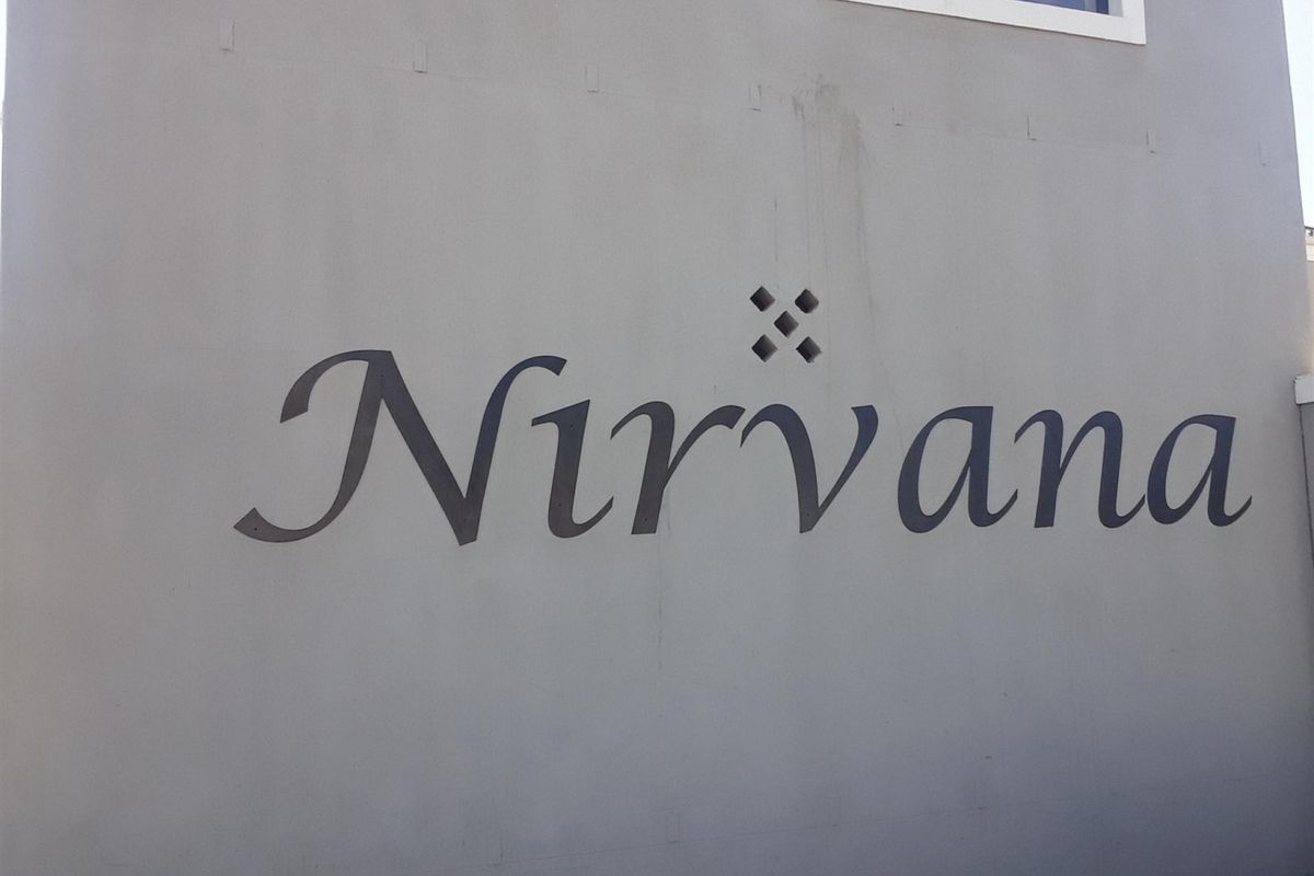 Exterior view of the building facade featuring the Nirvana complex signage on a painted wall surface.