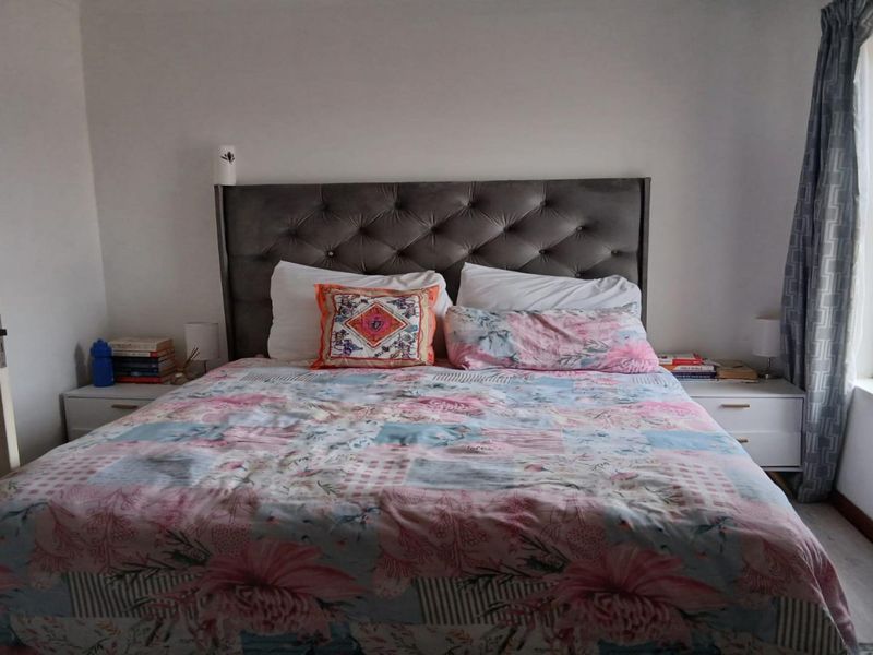 A standard bedroom featuring a window with curtains and a door, providing a functional and private sleeping space.