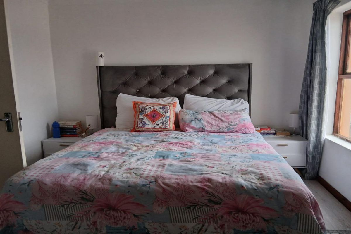 A standard bedroom featuring a window with curtains and a door, providing a functional and private sleeping space.