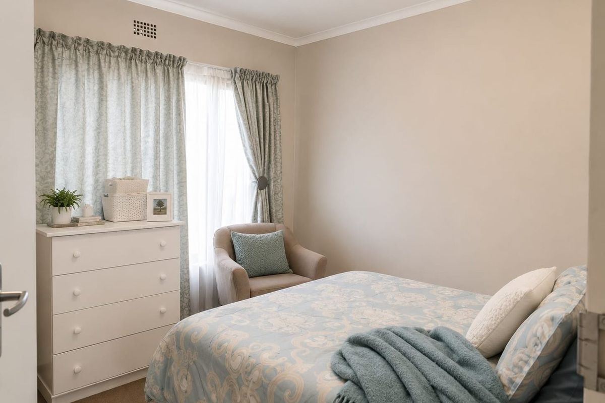 A well-maintained bedroom featuring neutral wall tones, recessed downlighting, and a ventilation grille, offering a comfortable and functional living space.