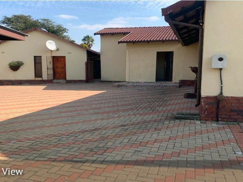 Spacious paved front courtyard area providing access to the main dwelling and outbuildings with established brick and tile exterior finishes.