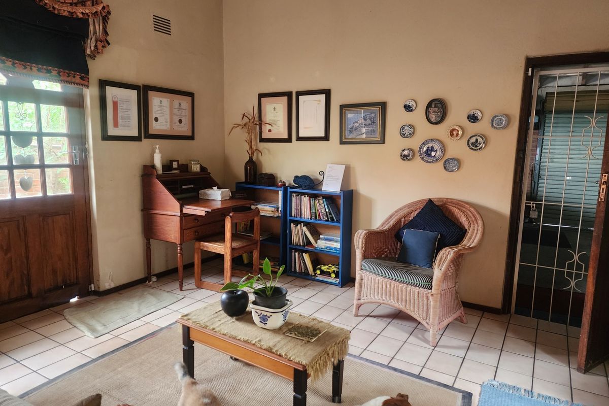 A living area featuring tiled flooring and a timber door with security gate access, providing a functional and well-lit space.