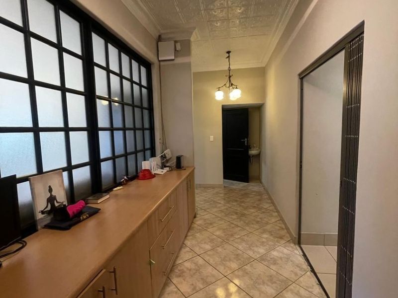 A functional hallway featuring built-in cabinetry, tiled flooring, and a decorative pressed metal ceiling, providing ample storage and access to adjacent rooms.