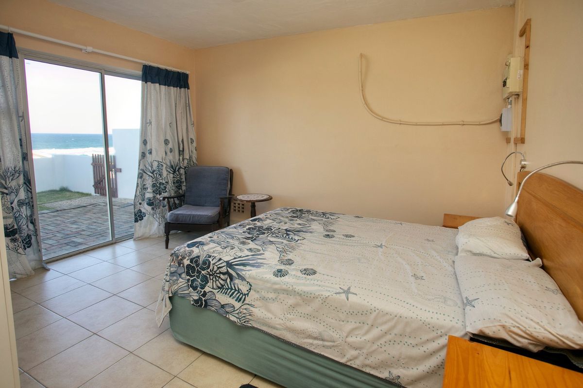 Bedroom featuring ceramic floor tiles and a sliding glass door providing direct access to an outdoor patio with ocean views.