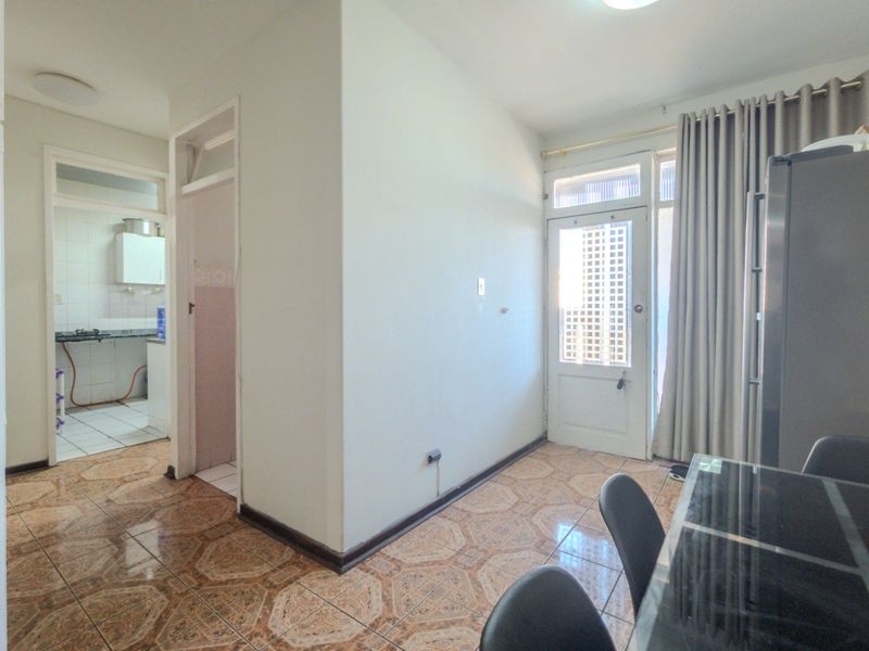 Open plan living area featuring tiled flooring and direct access to an exterior space through a glass panel door.