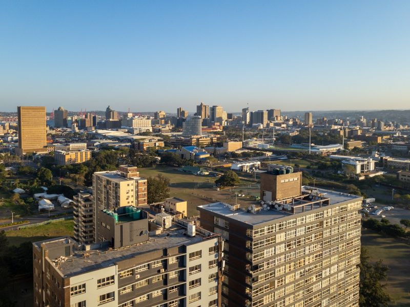 An elevated aerial view showcasing the surrounding urban cityscape and high-rise apartment buildings.