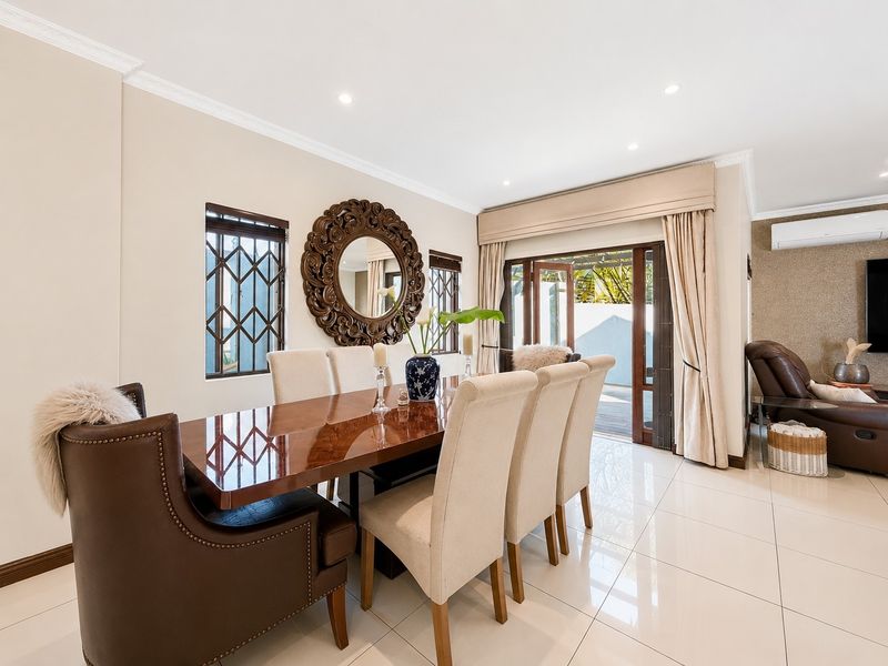 Bright dining area featuring polished porcelain floor tiles, recessed lighting, and direct access to an outdoor patio through sliding glass doors.