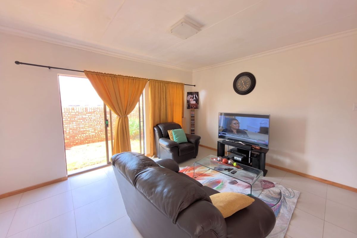 A living room featuring tiled flooring and a sliding glass door providing access to the exterior.