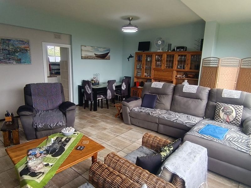 Spacious open-plan living and dining area featuring neutral wall tones and tiled flooring, providing a versatile layout for comfortable daily living.