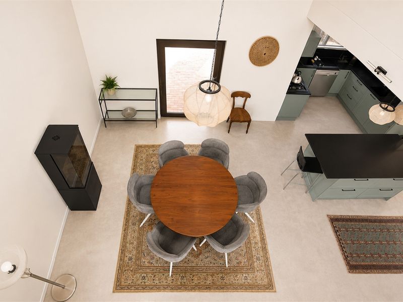 Spacious open-plan living and dining area featuring a modern kitchen with island, sleek cabinetry, and a contemporary freestanding fireplace.