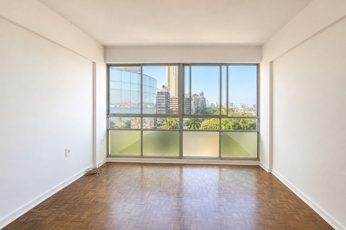 A bright, empty bedroom featuring classic parquet flooring and large sliding windows that offer expansive city and harbour views.