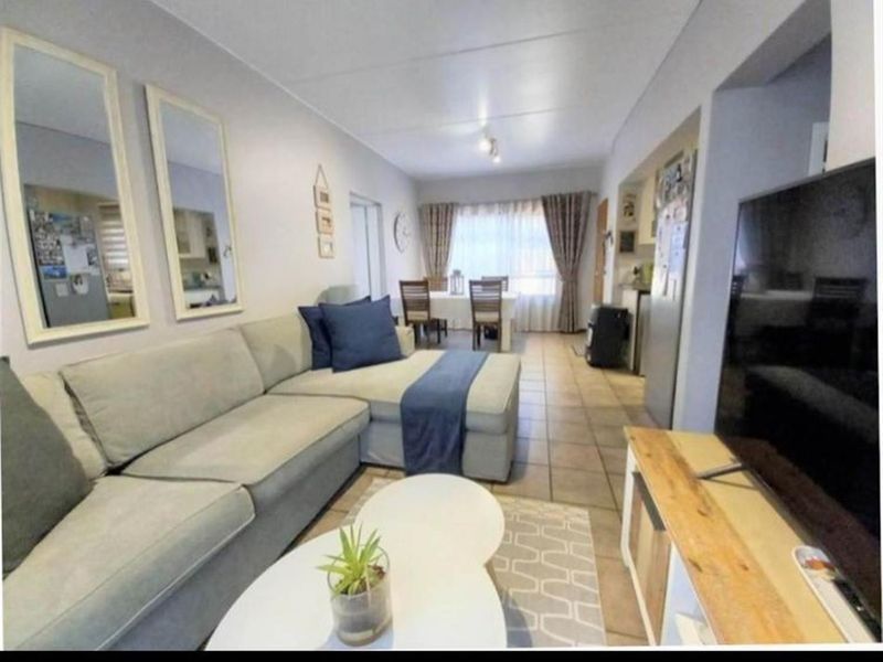 Open-plan living and dining area featuring tiled flooring and a functional layout connecting to the kitchen space.