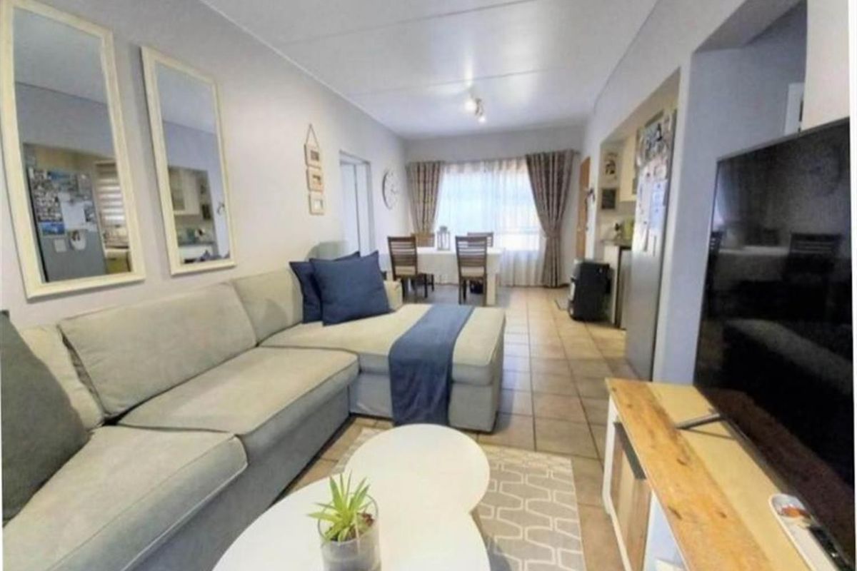 Open-plan living and dining area featuring tiled flooring and a functional layout connecting to the kitchen space.