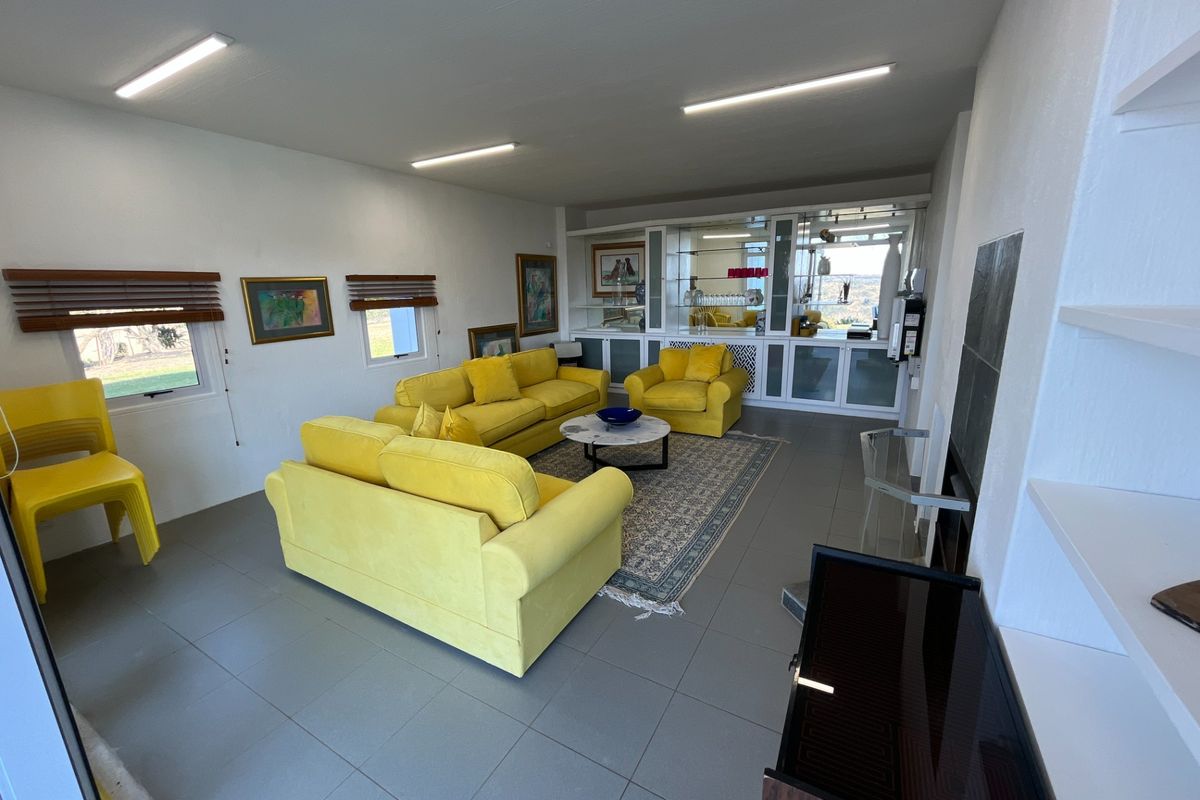 Spacious living room featuring tiled flooring, built-in display cabinetry, and ample natural light, offering a versatile layout for comfortable family living.