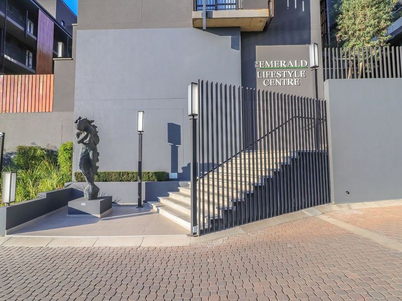 Modern entrance to The Emerald Lifestyle Centre featuring a paved driveway, concrete staircase, and contemporary architectural lighting.
