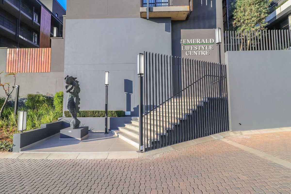 Modern entrance to The Emerald Lifestyle Centre featuring a paved driveway, concrete staircase, and contemporary architectural lighting.