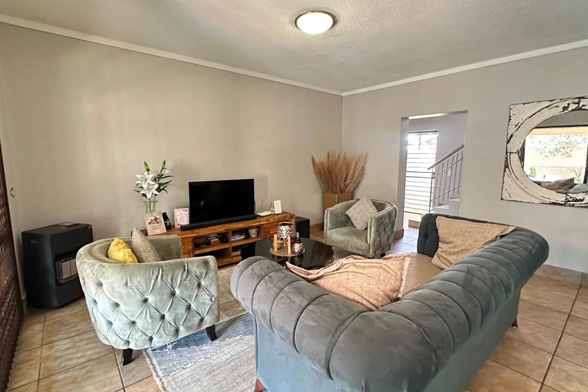 A comfortable living room featuring tiled flooring and a neutral color palette, providing a functional space for relaxation and daily living.
