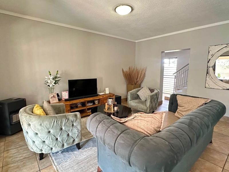 A comfortable living room featuring tiled flooring and a neutral color palette, providing a functional space for relaxation and daily living.