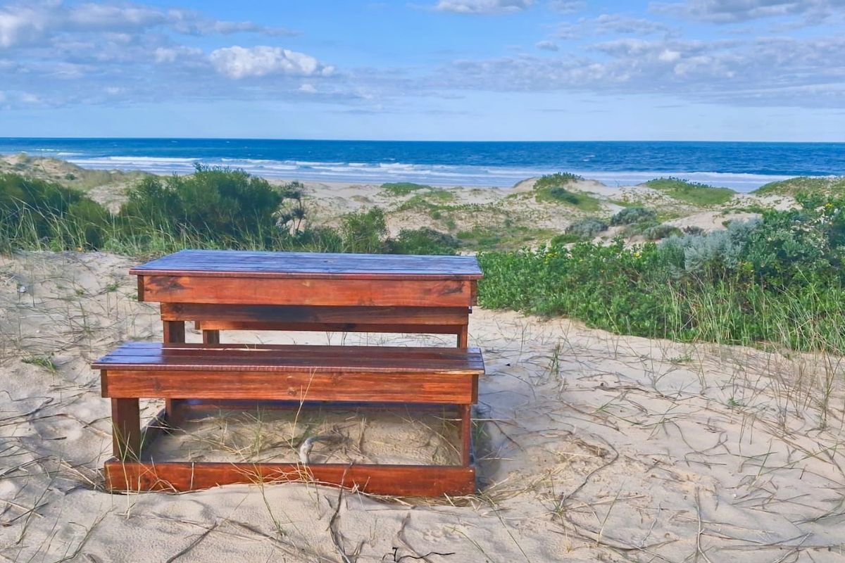 A scenic view of the ocean and coastal sand dunes, showcasing the natural landscape of the vacant residential property.