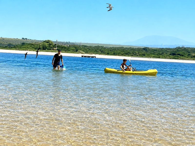 A scenic view of a clear water lagoon and natural landscape, highlighting the recreational potential of the surrounding environment.