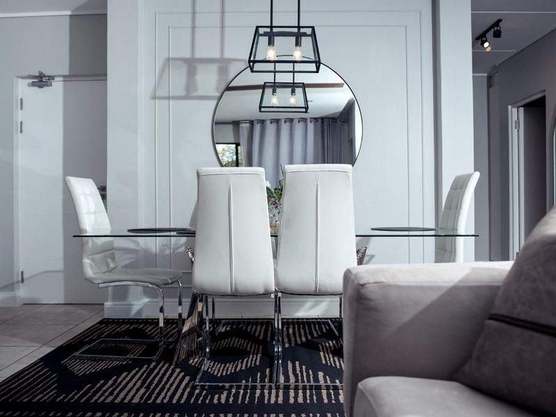 Modern dining area featuring elegant wainscoting, tiled flooring, and contemporary lighting fixtures, creating a sophisticated and well-maintained space.