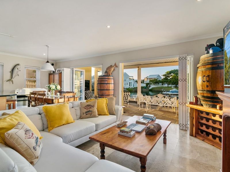 Spacious open-plan living and dining area featuring stone flooring, recessed lighting, and seamless indoor-outdoor flow through bi-fold doors to the patio.