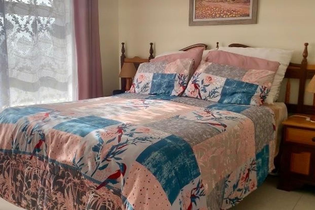 A bedroom featuring a large window allowing natural light, providing a comfortable and functional sleeping space.