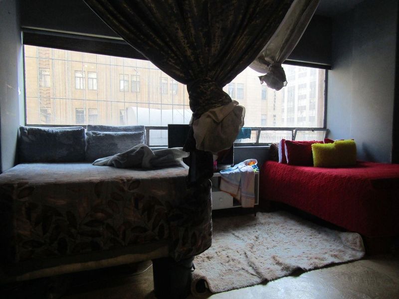 A bedroom featuring a large window with city views, providing natural light to the space.