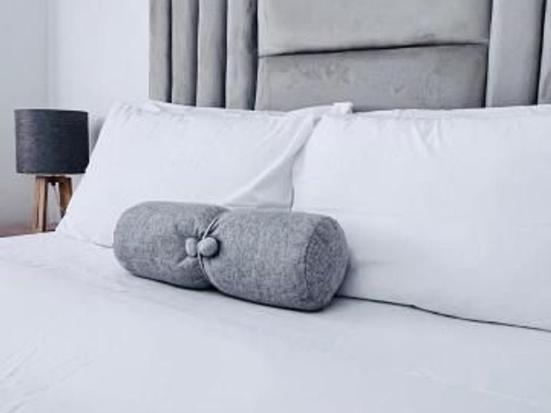 A close-up view of a bedroom featuring a modern upholstered headboard.