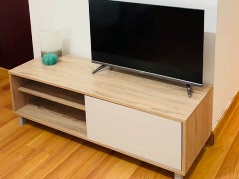 A living area featuring light-toned laminate flooring and neutral wall finishes.
