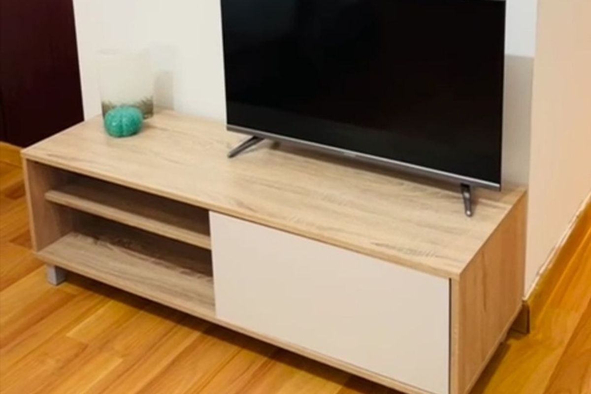 A living area featuring light-toned laminate flooring and neutral wall finishes.
