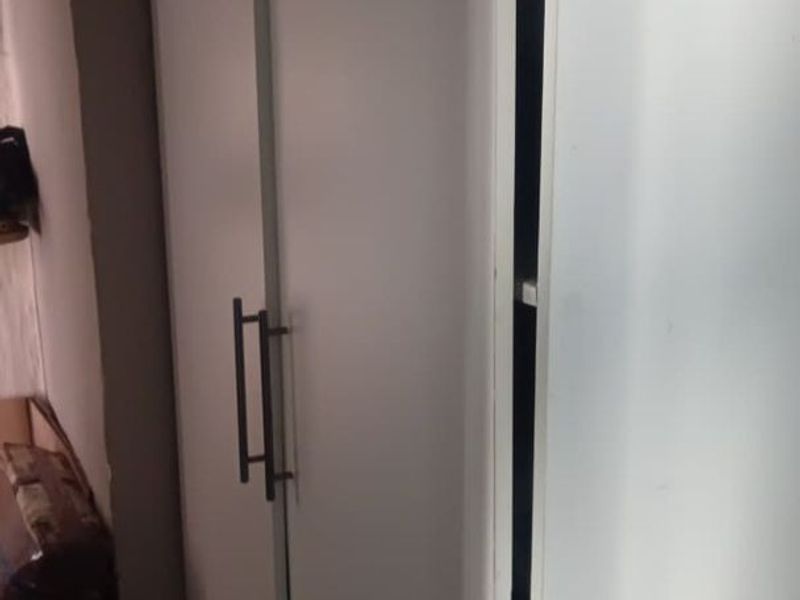 A close-up view of white built-in cabinetry showing signs of misalignment and wear.