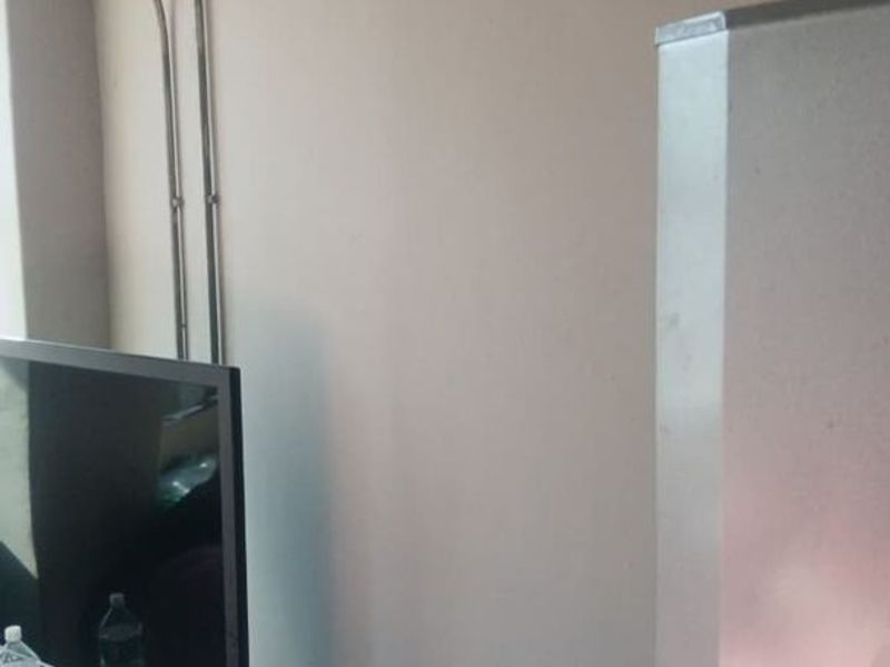 A living area space featuring visible surface-mounted electrical conduit along the wall, requiring cosmetic attention to improve the aesthetic appeal.