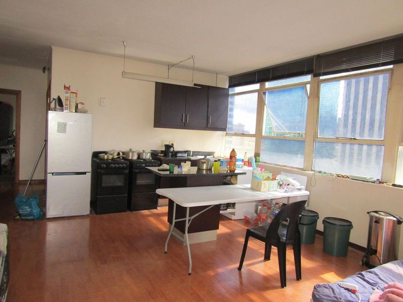 Open-plan kitchen and living area featuring dark cabinetry, granite countertops, and large windows providing ample natural light.
