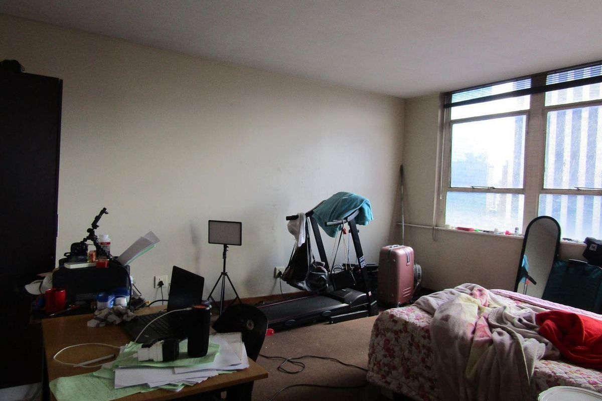 A bedroom featuring a large window providing natural light, with carpeted flooring and neutral wall finishes.