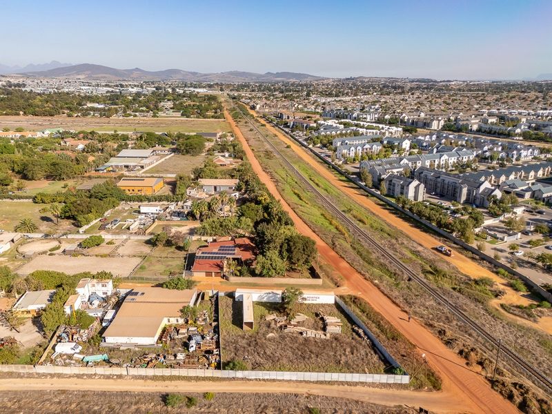 Aerial view of the residential property and surrounding area, featuring proximity to the railway line and local infrastructure.