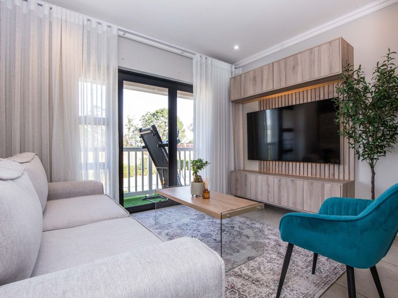 Modern living room featuring a custom built-in media unit, tiled flooring, and large sliding glass doors leading to a balcony.
