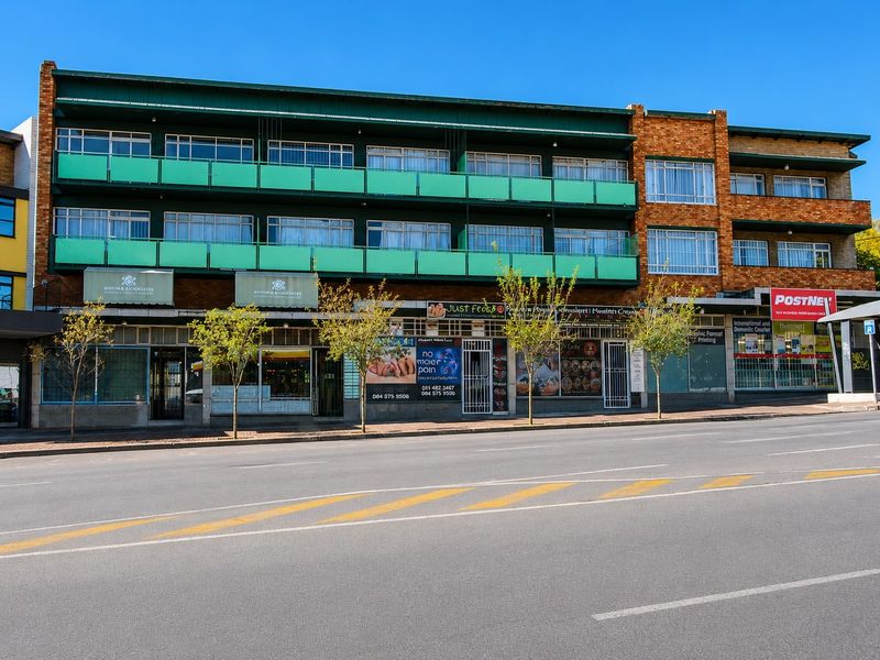 A multi-story commercial building featuring ground-level retail storefronts and upper-level office or residential units with balconies.