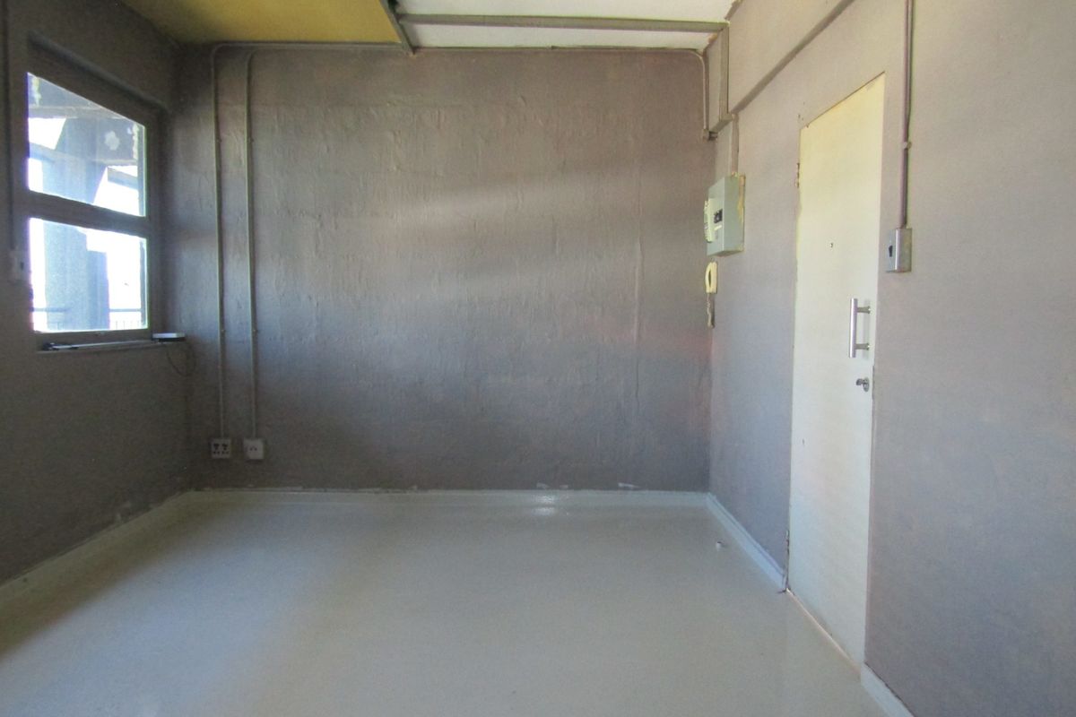 An empty bedroom featuring exposed electrical conduits and basic finishes, requiring renovation to improve the aesthetic and overall condition of the space.