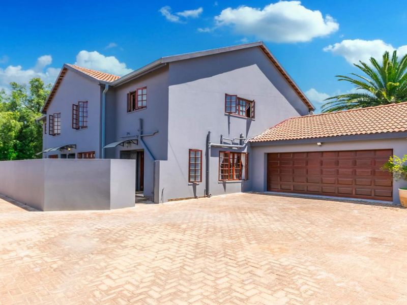 A well-maintained double-story residential property featuring a paved driveway, integrated garage, and neutral exterior finish.