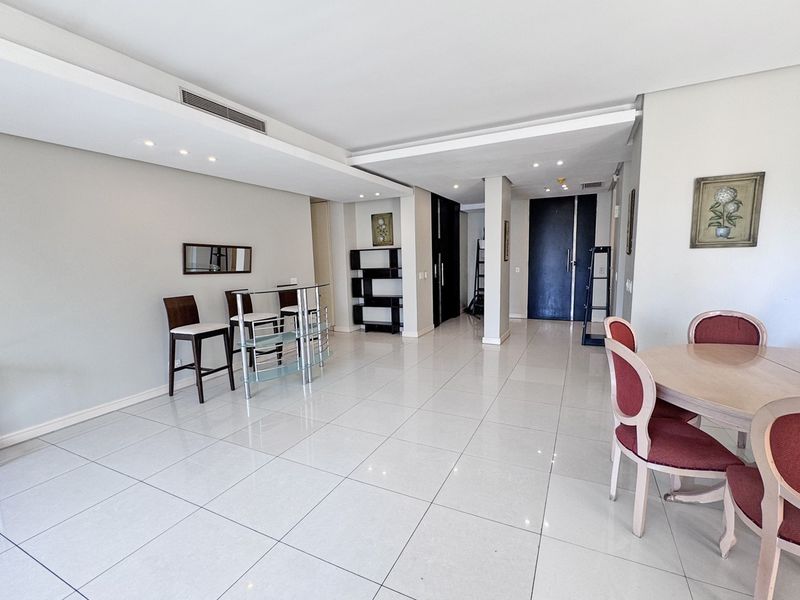 Spacious open-plan living and dining area featuring neutral tiled flooring, recessed ceiling lighting, and integrated ducted air conditioning.